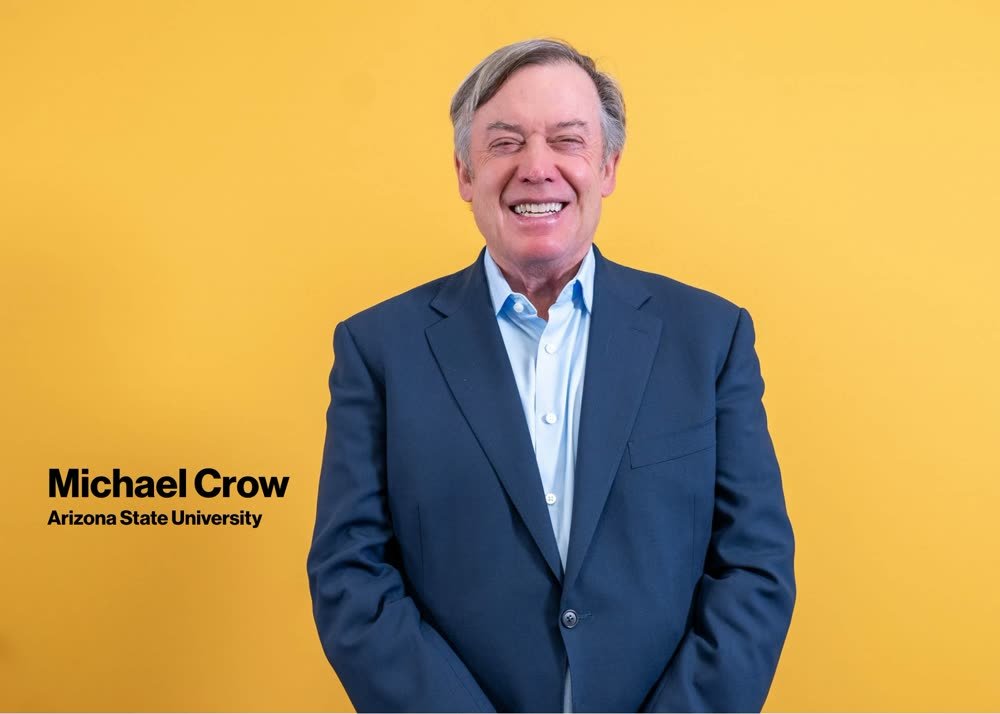 Portrait of Michael Crow, Arizona State University, smiling against a gold backdrop